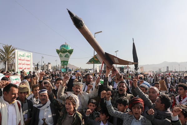 Houthi supporters carry a mock rocket and chant slogans during an anti-Israel rally in Sanaa, Yemen, Friday, Dec. 27, 2024. (AP Photo/Osamah Abdulrahman)