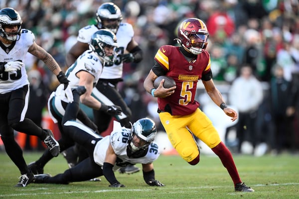 Washington Commanders quarterback Jayden Daniels (5) running with the ball during the second half of an NFL football game against the Philadelphia Eagles, Sunday, Dec. 22, 2024, in Landover, Md. (AP Photo/Nick Wass)