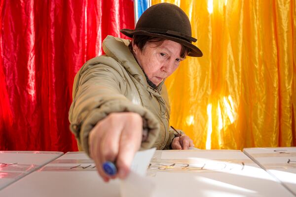 A woman casts her vote in the country's presidential elections, in Bucharest, Romania, Sunday, Nov. 24, 2024. (AP Photo/Andreea Alexandru)