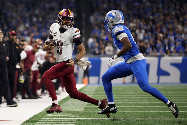 Detroit Lions cornerback Terrion Arnold (0) runs Washington Commanders quarterback Jayden Daniels (5) out of bounds during the second half of an NFL football divisional playoff game, Saturday, Jan. 18, 2025, in Detroit. (AP Photo/Mike Mulholland)