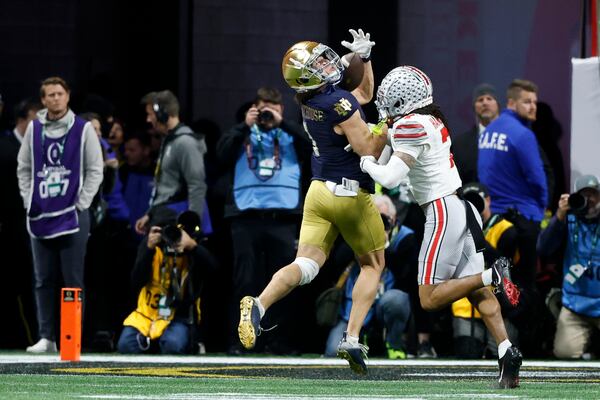 Notre Dame wide receiver Jaden Greathouse catches a touchdown pass ahead of Ohio State cornerback Jordan Hancock during second half of the College Football Playoff national championship game Monday, Jan. 20, 2025, in Atlanta. (AP Photo/Butch Dill)