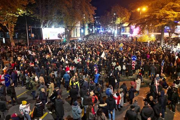 Protesters gather in a street during a rally against the results of the parliamentary elections amid allegations that the vote was rigged in Tbilisi, Georgia, late Tuesday, Nov. 19, 2024. (AP Photo/Zurab Tsertsvadze)