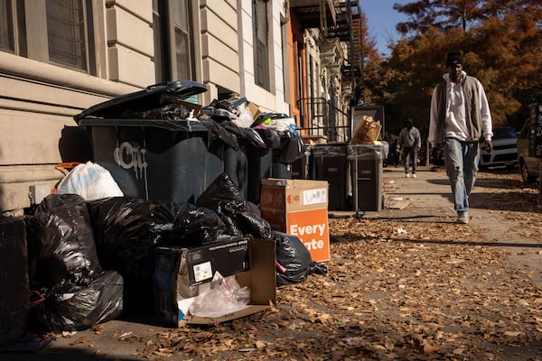 A person walks next to the pile of trash, Friday, Nov. 15, 2024, in the Brooklyn borough of New York. (AP Photo/Yuki Iwamura)