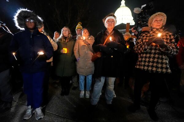 Supporters hold candles during a candlelight vigil Tuesday, Dec. 17, 2024, outside the Wisconsin Capitol in Madison, Wis., following a shooting at the Abundant Life Christian School on Monday, Dec. 16. (AP Photo/Morry Gash)