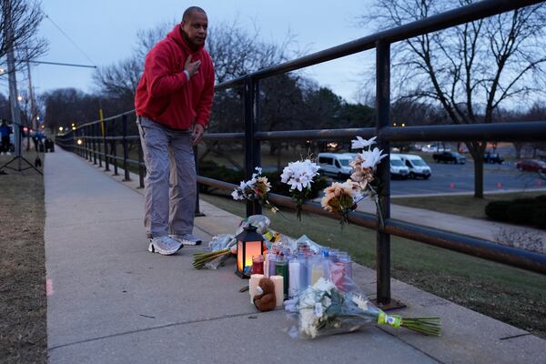 A person who did not wish to give his name places flowers outside the Abundant Life Christian School Tuesday, Dec. 17, 2024 in Madison, Wis., following a shooting on Monday. (AP Photo/Nam Y. Huh)