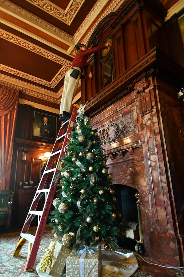 Bethany Gill winds a clock in the office of Pennsylvania's lieutenant governor, Dec. 13, 2024, in Harrisburg, Pa. It's one of 273 clocks in Pennsylvania's ornate state Capitol complex buildings that must be wound by hand. (AP Photo/Marc Levy)