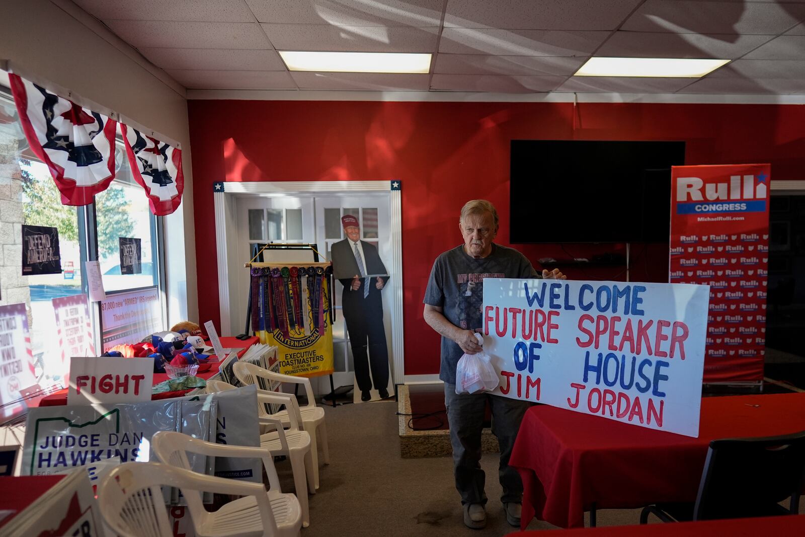 Donald Skowron holds the "Welcome Future Speaker of House Jim Jordan," sign that he made after Rep. Jim Jordan, R-Ohio, spoke at a rally for Rep. Michael Rulli, R-Ohio, at the Mahoning County Republican Party headquarters in Boardman, Ohio, Thursday, Oct. 17, 2024. A cardboard cutout of Republican presidential nominee former President Donald Trump is seen behind. (AP Photo/Carolyn Kaster)