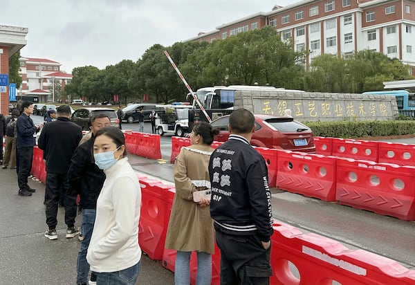 Guardians gather in front of the Wuxi Vocational Institute of Arts and Technology in Yixing, eastern Chinese city of Wuxi Sunday, Nov. 17, 2024, a day after a stabbing attack took place. (Kyodo News via AP)