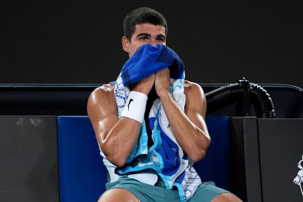 Carlos Alcaraz of Spain rests during his quarterfinal match against Novak Djokovic of Serbia at the Australian Open tennis championship in Melbourne, Australia, Tuesday, Jan. 21, 2025. (AP Photo/Ng Han Guan)