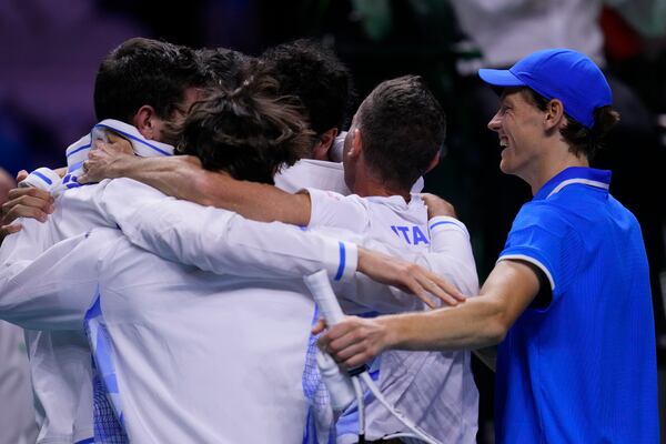 Italy's Jannik Sinner, right, celebrates with teammates after defeating Netherlands' Tallon Griekspoor to win Italy's second consecutive Davis Cup title at the Martin Carpena Sports Hall in Malaga, southern Spain, Sunday, Nov. 24, 2024. (AP Photo/Manu Fernandez)