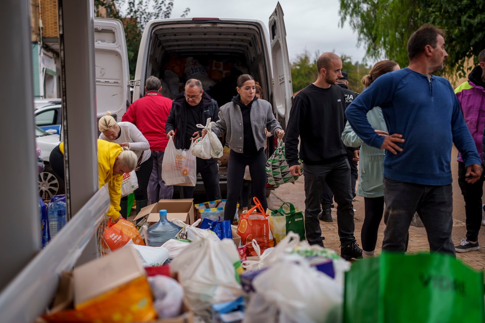 People collect food in an area affected by floods in Chiva, Spain, Friday, Nov. 1, 2024. (AP Photo/Manu Fernandez)