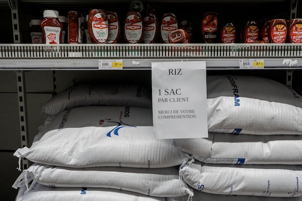 A sign asks customers to only purchase one bag of rice per person in Mamoudzou, Mayotte, Thursday, Dec. 19, 2024 (AP Photo/Adrienne Surprenant)