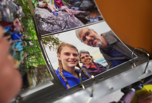 Zoey Stapleton flips through family photos in her childhood home in Palmyra, Pa., Tuesday, July 2, 2024. (AP Photo/Jessie Wardarski)