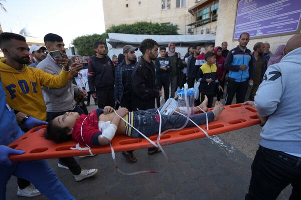 A wounded Palestinian child is carried on a stretcher at the Al-Aqsa Martyrs hospital in Deir al-Balah, following an Israeli bombardment in Nuseirat, central Gaza, Wednesday, Dec. 4, 2024. (AP Photo/Abdel Kareem Hana)