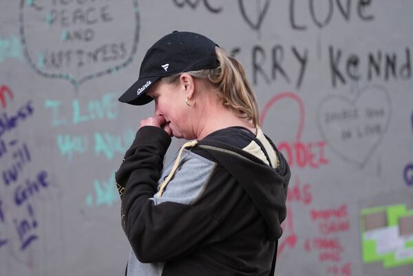 Alisa Kuhns, visiting from Santa Rosa, Calif. reacts at memorial on Bourbon Street for the victims of a deadly truck attack on New Year's Day in New Orleans, Friday, Jan. 3, 2025. (AP Photo/Gerald Herbert)