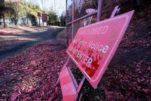 Retardant covers a sign after after crews battled the Palisades Fire in Mandeville Canyon Monday, Jan. 13, 2025 in Los Angeles. (AP Photo/Richard Vogel)