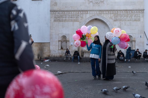 People pose for photos with balloons near Al-Hamidiyeh Souq on New Years Eve, in Damascus, Syria, Tuesday, Dec. 31, 2024 (AP Photo/Mosa'ab Elshamy)