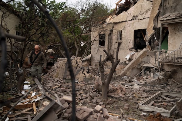 A member of the Israeli forces inspect a site following a rocket fired from Lebanon hit an area in Rinatya, outskirts of Tel Aviv, Israel, Sunday, Nov. 24, 2024. (AP Photo/Leo Correa)