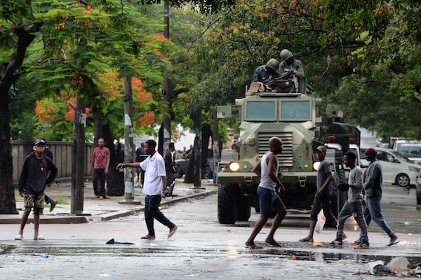 Mozambique's Defence Forces members watch the crowd on the street during the arrival of opposition leader Venancio Mondlane in Maputo, Mozambique, Thursday, Jan. 9, 2025. (AP Photo/Carlos Uqueio)