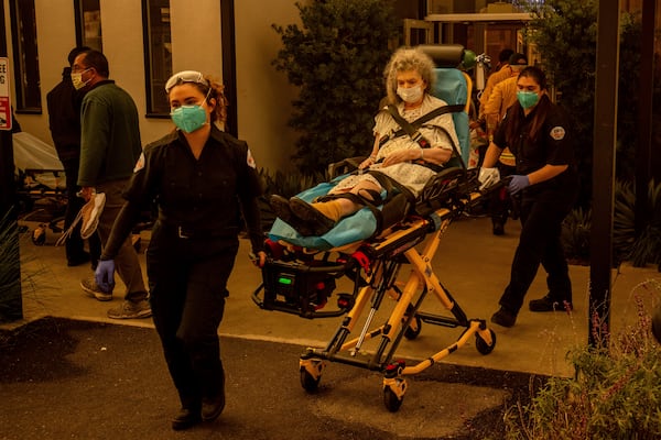 A resident is evacuated from a senior living facility as the Eaton Fire approaches Wednesday, Jan. 8, 2025, in Altadena, Calif. (AP Photo/Ethan Swope)