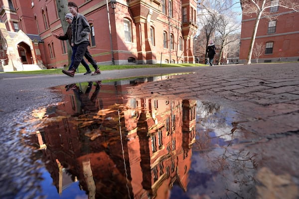 People walk between buildings, Tuesday, Dec. 17, 2024, on the campus of Harvard University in Cambridge, Mass. (AP Photo/Steven Senne)