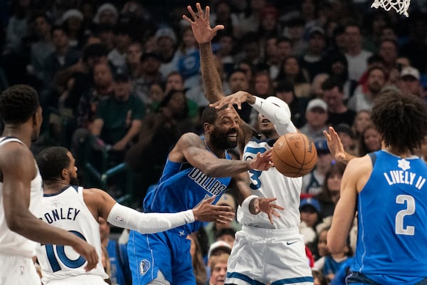 Dallas Mavericks guard Kyrie Irving (11) attempts to pass the ball to Dallas Mavericks center Dereck Lively II (2) in the first half of an NBA basketball game against the Minnesota Timberwolves on Wednesday, Dec. 25, 2024, in Dallas. (AP Photo/Emil T. Lippe)