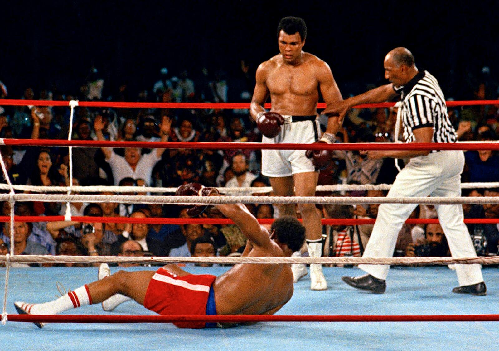 FILE - In this Oct. 30, 1974 file photo, referee Zack Clayton, right, steps in after challenger Muhammad Ali looks on after knocking down defending heavyweight champion George Foreman in the eighth round of their championship bout in Kinshasa, Zaire. (AP Photo/File)