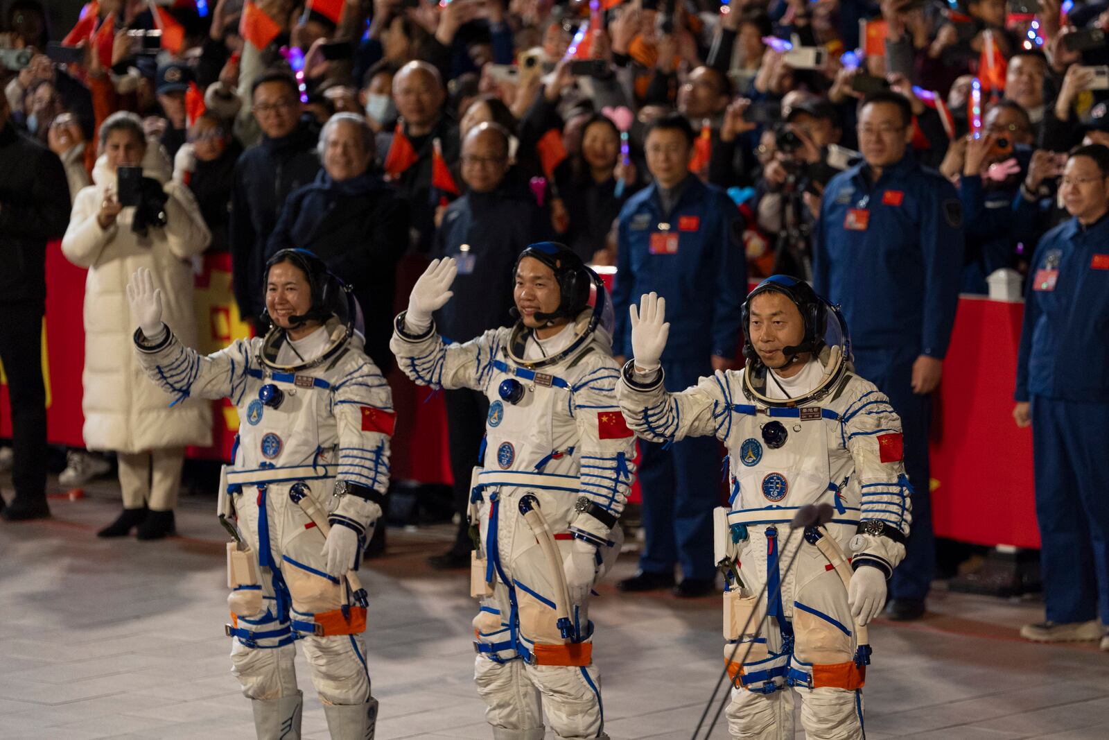 Chinese astronauts Wang Haoze, from left, Song Lingdong and Cai Xuzhe wave during the see-off ceremony for the Shenzhou-19 mission at the Jiuquan Satellite Launch Center in northwestern China, in the early hours of Wednesday, Oct. 30, 2024. (AP Photo/Ng Han Guan)