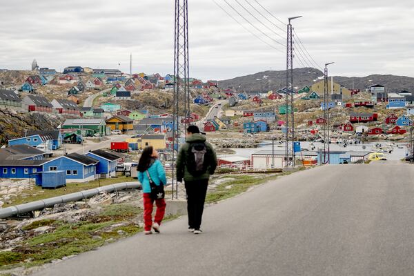 FILE - People walk in the town of Aasiaat, in western Greenland, located on its namesake island in the heart of Aasiaat Archipelago at the southern end of Disko Bay, in Greenland, Saturday, June 29, 2024. (Ida Marie Odgaard/Ritzau Scanpix via AP, File)