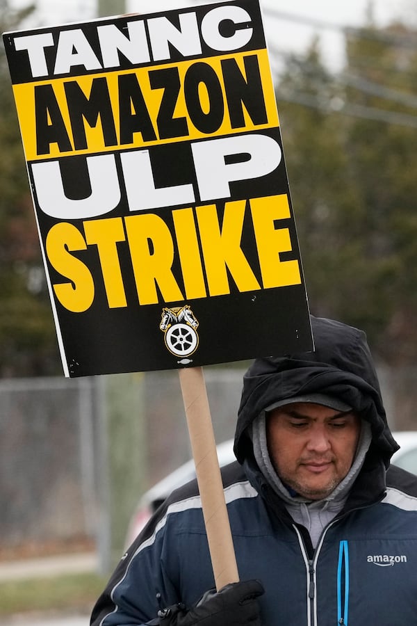 A striker holds a sign during a strike at Skokie (DIL7) Amazon Delivery station in Skokie, Ill., Thursday, Dec. 19, 2024. (AP Photo/Nam Y. Huh)