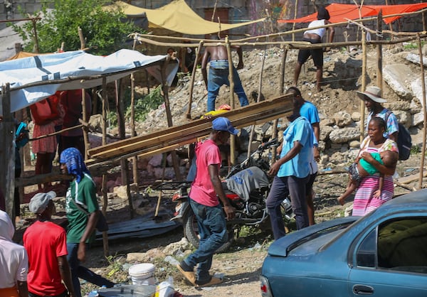 Residents of the Nazon neighborhood displaced by gang violence construct a tent encampment, in Port-au-Prince, Haiti, Friday, Nov. 15, 2024. (AP Photo/Odelyn Joseph)