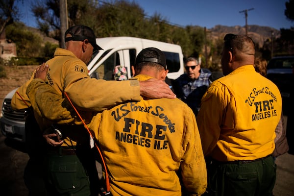 Firefighters with the U.S. Forest Service gather to pray, Wednesday, Jan. 15, 2025, in Altadena, Calif. (AP Photo/John Locher)