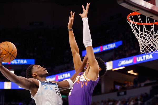 Minnesota Timberwolves guard Anthony Edwards (5) goes to the basket against Phoenix Suns forward Royce O'Neale (0) in the first quarter of an NBA basketball game Sunday, Nov. 17, 2024, in Minneapolis. (AP Photo/Bruce Kluckhohn)