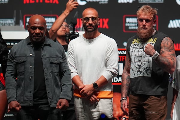 Mike Tyson, left, and Jake Paul, right, pose for photographs during a news conference ahead of their fight, Wednesday, Nov. 13, 2024, in Irving, Texas. (AP Photo/Julio Cortez)