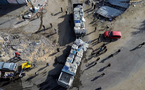 A drone photo shows humanitarian aid trucks enter through the Kerem Shalom crossing from Egypt into the Gaza Strip, as a ceasefire deal between Israel and Hamas went into effect, Sunday, Jan. 19, 2025. (AP Photo/Jehad Alshrafi)