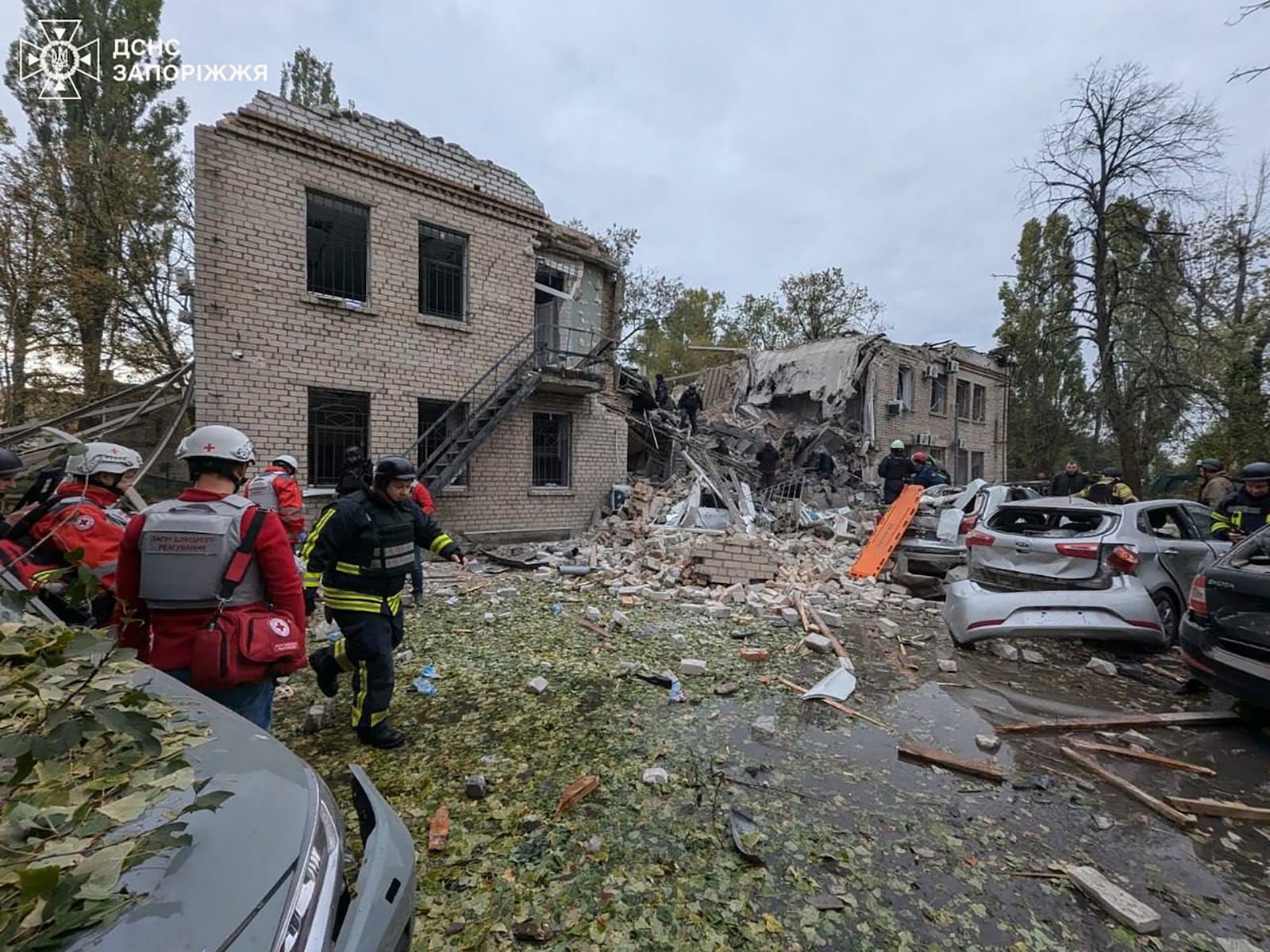 In this photo provided by the Ukrainian Emergency Service, emergency workers clear the rubble after Russia attacked the city with guided bombs overnight in Zaporizhzhia, Ukraine, Monday, Oct. 21, 2024. (Ukrainian Emergency Service via AP)