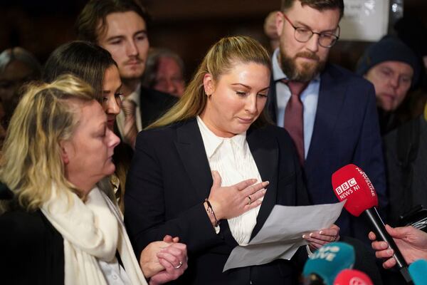 Nikita Hand, who is also known as Nikita Ni Laimhin, center, speaks with the media outside the High Court in Dublin, Ireland, Friday, Nov. 22, 2024, after a civil jury found that mixed martial arts fighter Conor McGregor sexually assaulted her in a hotel penthouse after a night of heavy partying. (Brian Lawless/PA via AP)