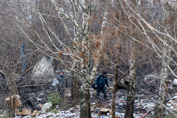 Lithuanian police investigators work near the site where a DHL cargo plane crashed into a house near the Lithuanian capital Vilnius, Lithuania, Lithuania, Monday, Nov. 25, 2024. (AP Photo/Mindaugas Kulbis)