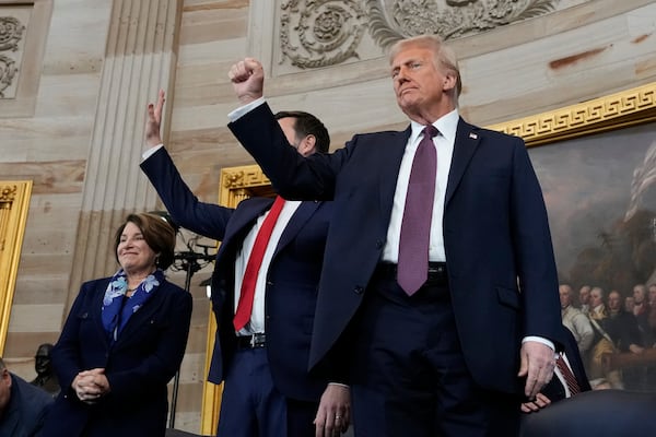 President Donald Trump, center, gestures as he is joined on stage by Vice President JD Vance after being sworn in as the 47th president of the United States during the 60th Presidential Inauguration in the Rotunda of the U.S. Capitol in Washington, Monday, Jan. 20, 2025. (AP Photo/Morry Gash, Pool)