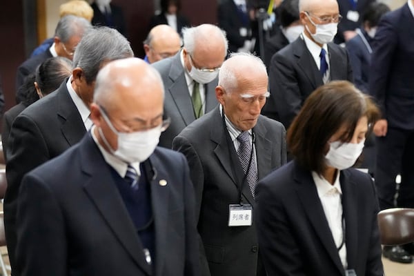 Guests offer a moment of silence during a memorial ceremony for the Sado Island Gold Mine in Sado, Niigata prefecture, Japan, Sunday, Nov. 24, 2024. (AP Photo/Eugene Hoshiko)