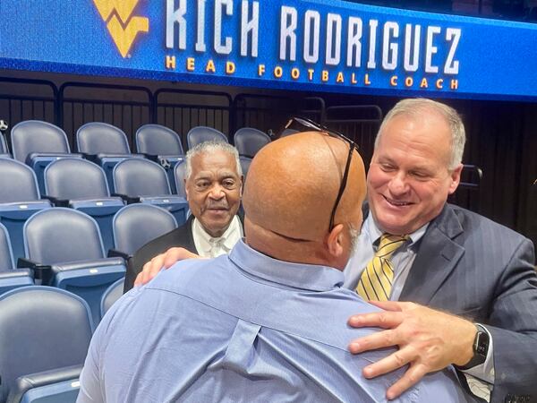 West Virginia coach Rich Rodriguez hugs a fan following his introductory NCAA college football news conference Friday, Dec. 13, 2024, in Morgantown, W.Va. (AP Photo/John Raby)