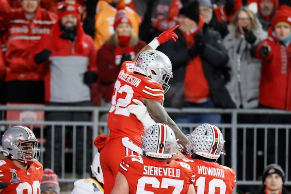 FILE - Ohio State running back TreVeyon Henderson, top, celebrates after his touchdown against Tennessee during the first half in the first round of the College Football Playoff, Saturday, Dec. 21, 2024, in Columbus, Ohio. (AP Photo/Jay LaPrete, File)