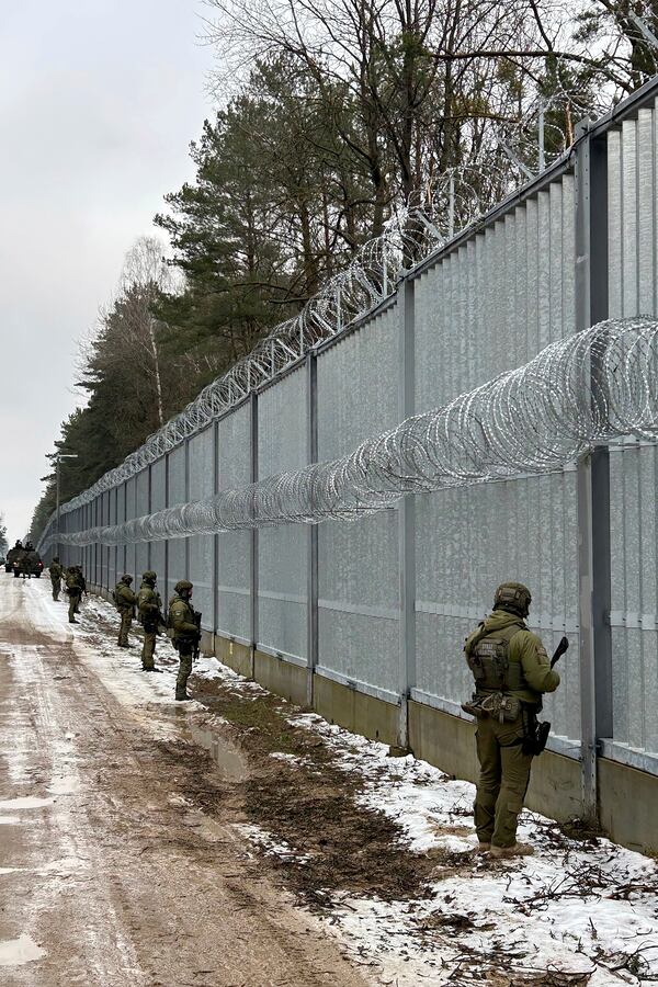 Polish border guards look east into Belarus at the crossing point Połowce-Pieszczatka in Polowce, Poland, Thursday, Jan. 16, 2025. (AP Photo/Lorne Cooke)