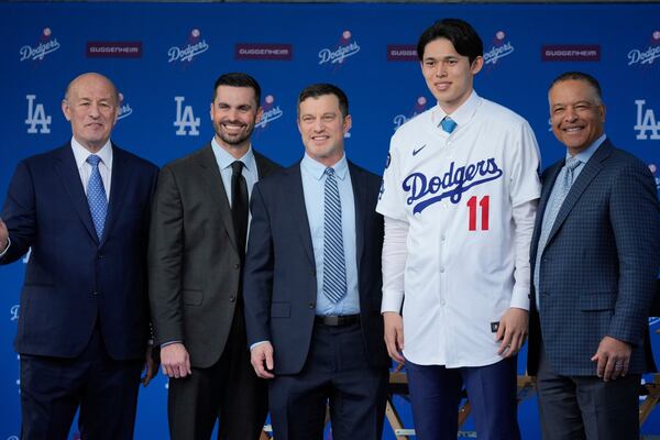 Japanese right-hander pitcher Roki Sasaki, 23, poses with Los Angeles Dodgers Pressident and CEO Stan Kasten, left, general manager Brandon Gomes, president of baseball operations Andrew Friedman and manager Dave Roberts, right, as he is introduced by the Los Angeles Dodgers at a news conference at Dodger Stadium Wednesday, Jan. 22, 2025 in Los Angeles. (AP Photo/Damian Dovarganes)