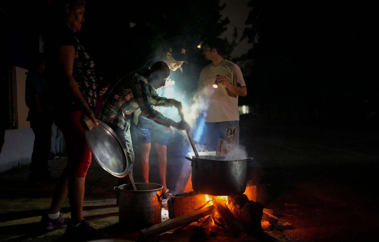 FILE - Residents prepare a soup over an open fire during a blackout following the failure of a major power plant in Havana, Cuba, Oct. 19, 2024. (AP Photo/Ramon Espinosa, File)