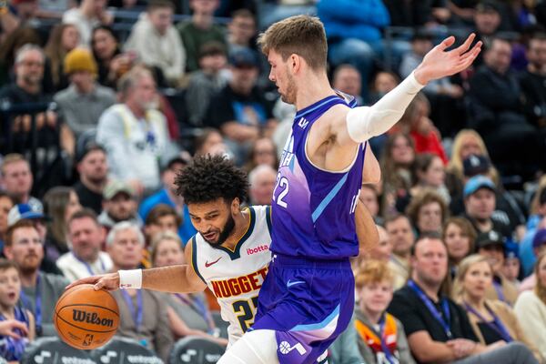 Denver Nuggets forward Spencer Jones. Left, tries to get by Utah Jazz forward Kyle Filipowski, right, during the first half of an NBA basketball game, Monday, Dec. 30, 2024, in Salt Lake City. (AP Photo/Rick Egan)