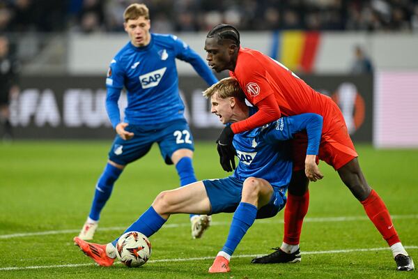 Hoffenheim's Max Moerstadt and Bucharest's Joyskim Dawa, rightm, in action during the Europa League opening phase soccer match between TSG 1899 Hoffenheim and FCSB Bucharest at PreZero Arena, Sinsheim, Germany, Thursday Dec. 12 2024. (Uwe Anspach/dpa via AP)