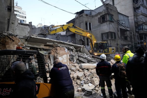 Rescuers use an excavator as they search for victims at the site of an Israeli airstrike that hit a building in Beirut, Lebanon, Tuesday, Nov. 26, 2024. (AP Photo/Hassan Ammar)