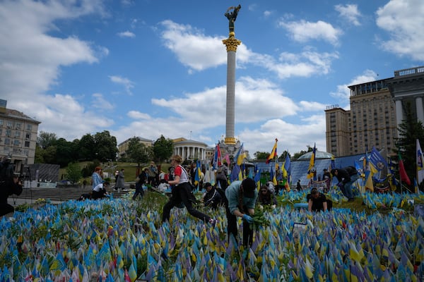 Volunteers put in order the site of an improvised memorial to fallen soldiers on Independence Square in Kyiv, Ukraine, Wednesday, May 15, 2024. (AP Photo/Efrem Lukatsky)