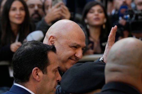 Newly-elected Lebanese President Joseph Aoun, center, smiles and waves to journalists upon his arrival at the Lebanese Parliament to be sworn in as a new president, in Beirut, Lebanon, Thursday, Jan. 9, 2025. (AP Photo/Hussein Malla)